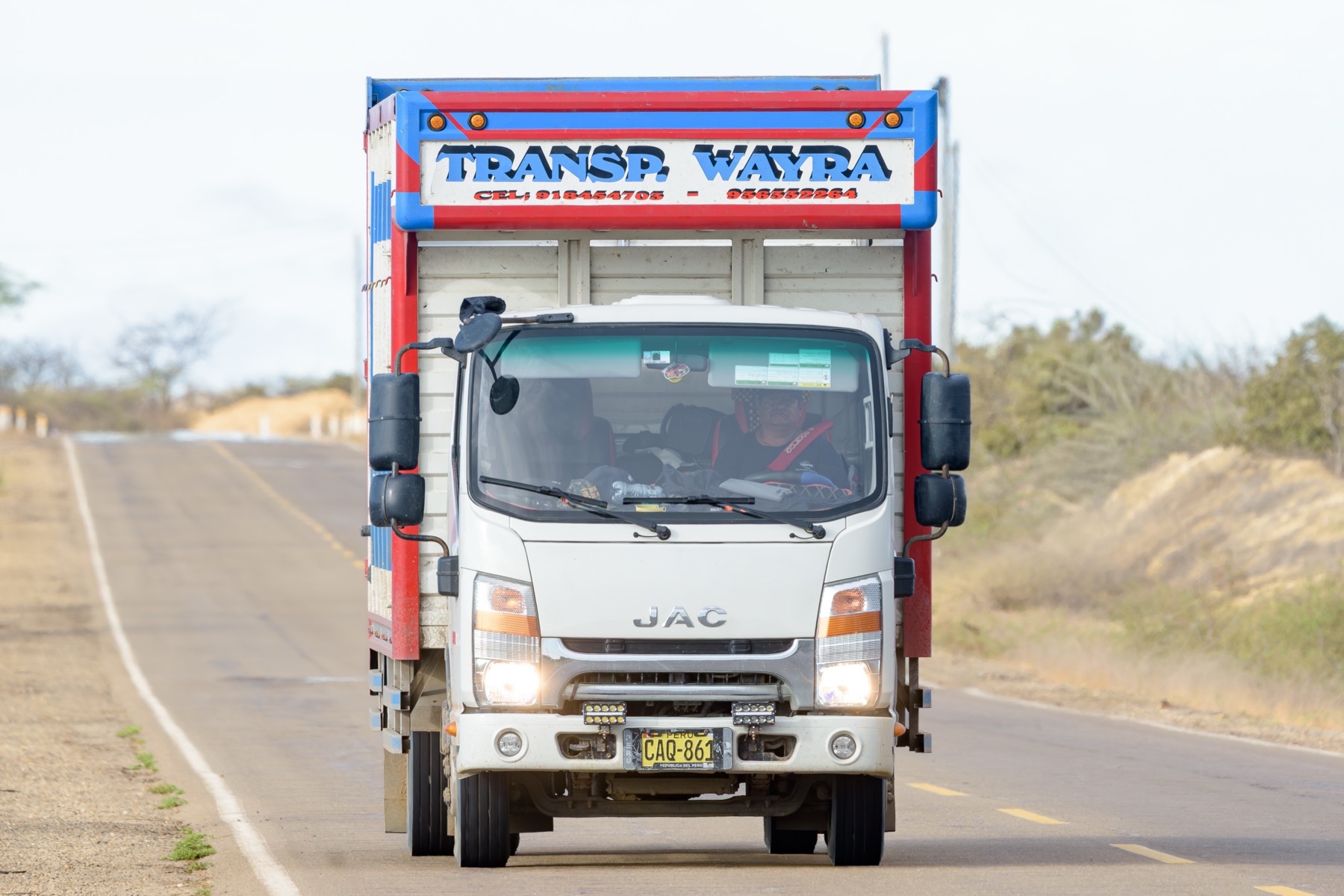 Camión furgón WAYRA JAC circulando de frente por una carretera costera